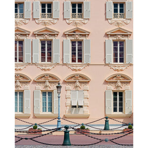 Pink building facade with decorative windows and shutters in Monaco